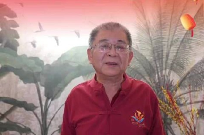 Li Laiqun in a red jacket in a broadcast frame