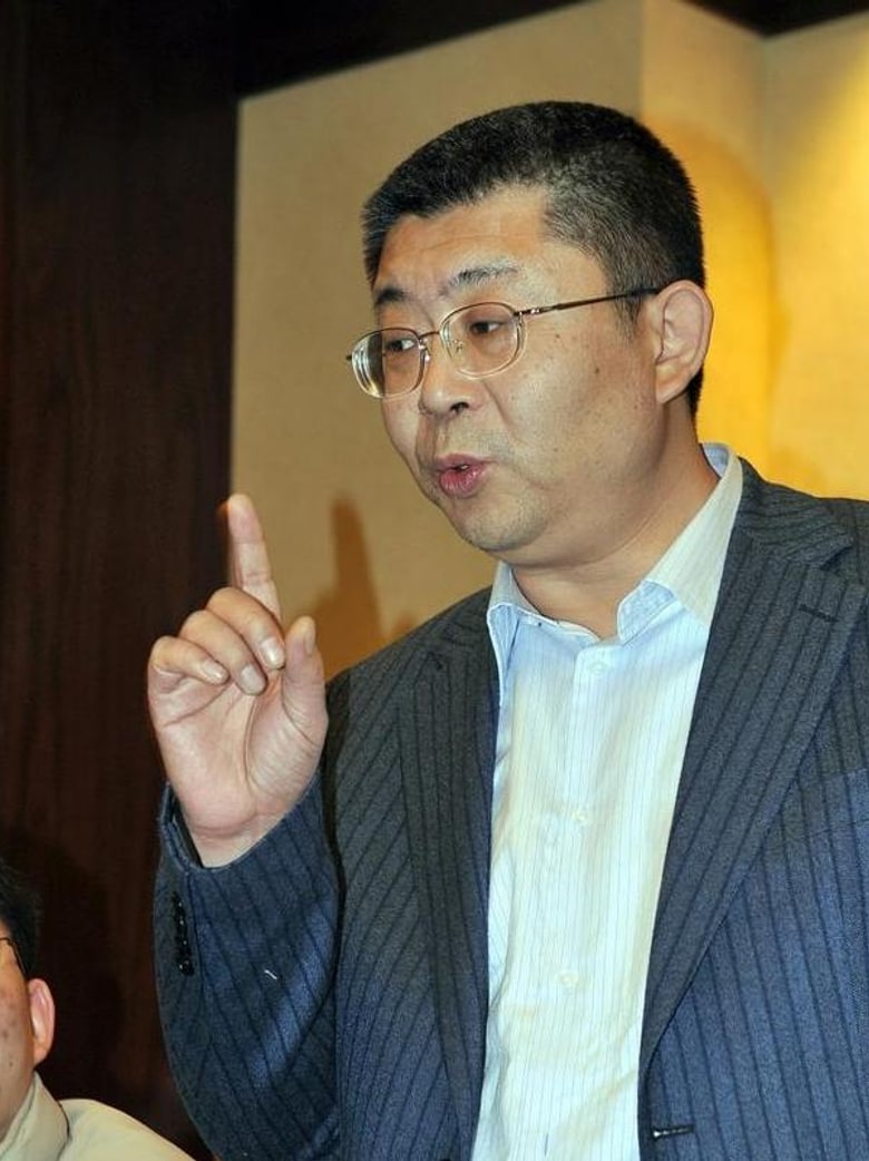 Li Laiqun gesturing as he speaks at an event